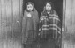 A Jewish woman and girl stand in the doorway of a wooden barracks in the Horodyszcze labor camp. ©United States Holocaust Memorial Museum, courtesy of Instytut Pamieci Narodowej