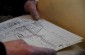 Vytautas G., born in 1929, showing our team a pre-war map of Rokiškis, which depicts the location of Jewish houses in the town. ©Cristian Monterroso/Yahad - In Unum