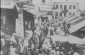 View into the crowded marketplace on market day. The Russian sign (left) advertises crockery. (From an album about the activities of ORT.) 1928© From the Archives of the YIVO Institute for Jewish Research